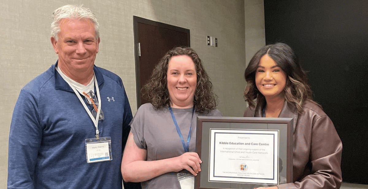 Two Kibble staff receiving an award from COO of CYC-NET