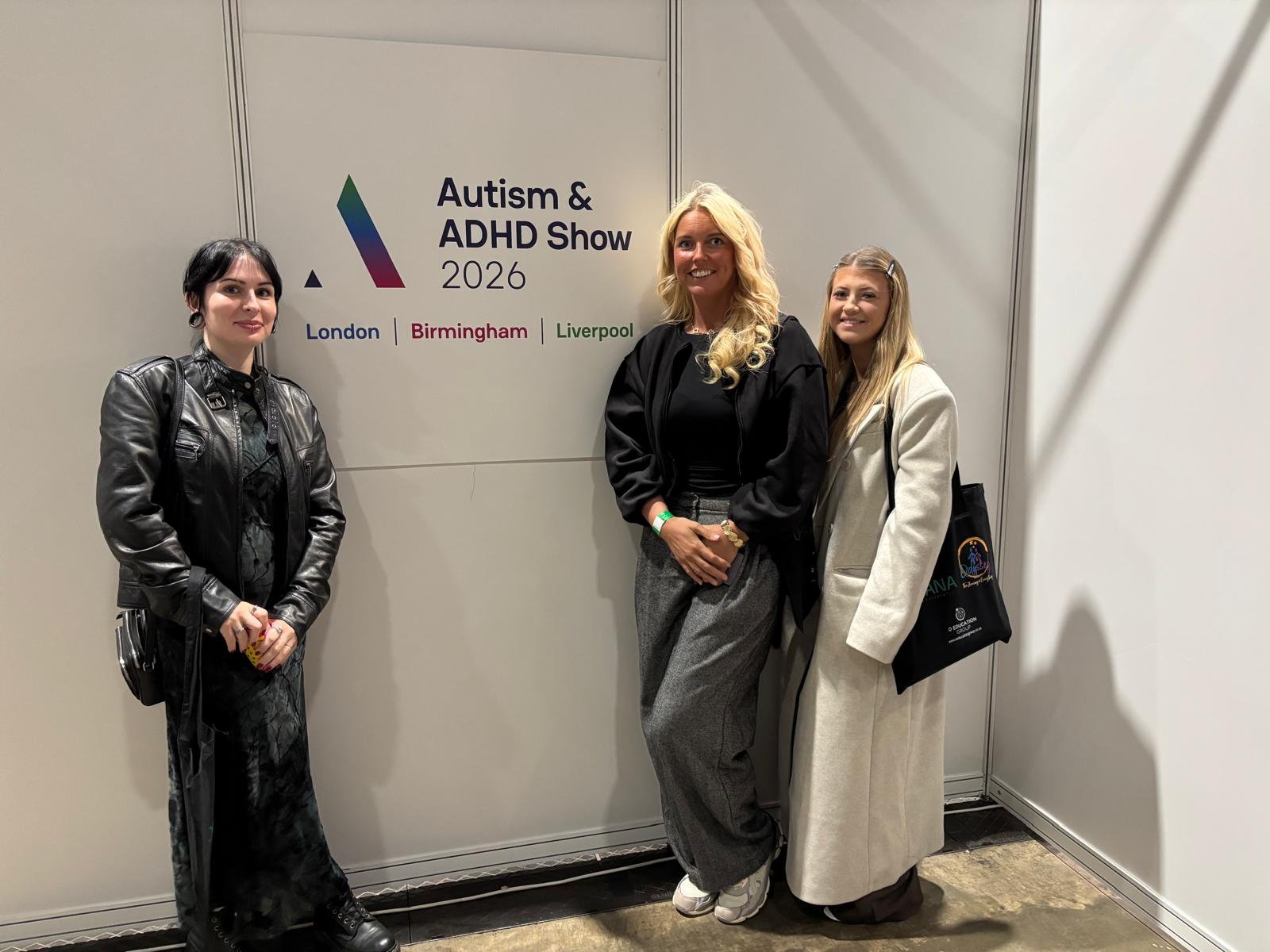 Three women from intensive services standing in front of conference sign