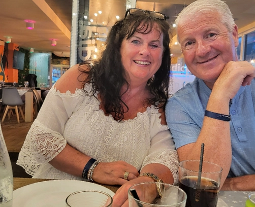 a man and woman at a table in a restaurant smiling into the camera