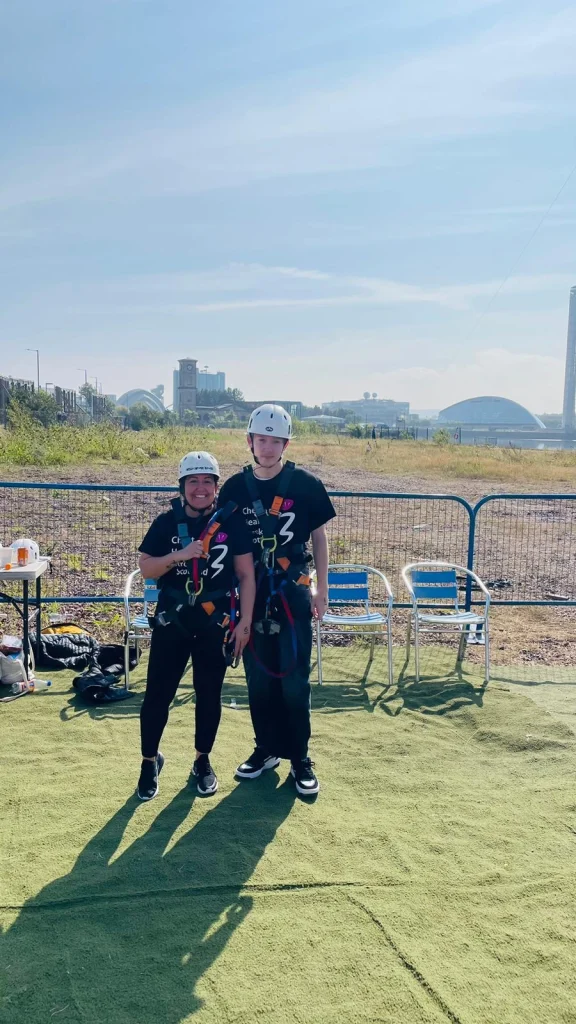 Young person with his Foster Care Key Worker in a field, wearing helmets