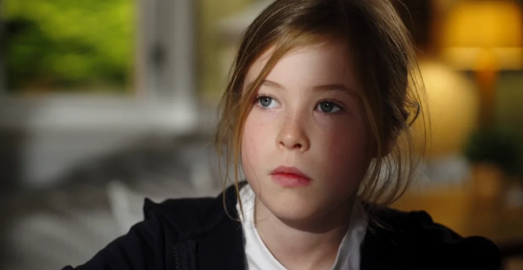 young girl at a desk talking to the camera